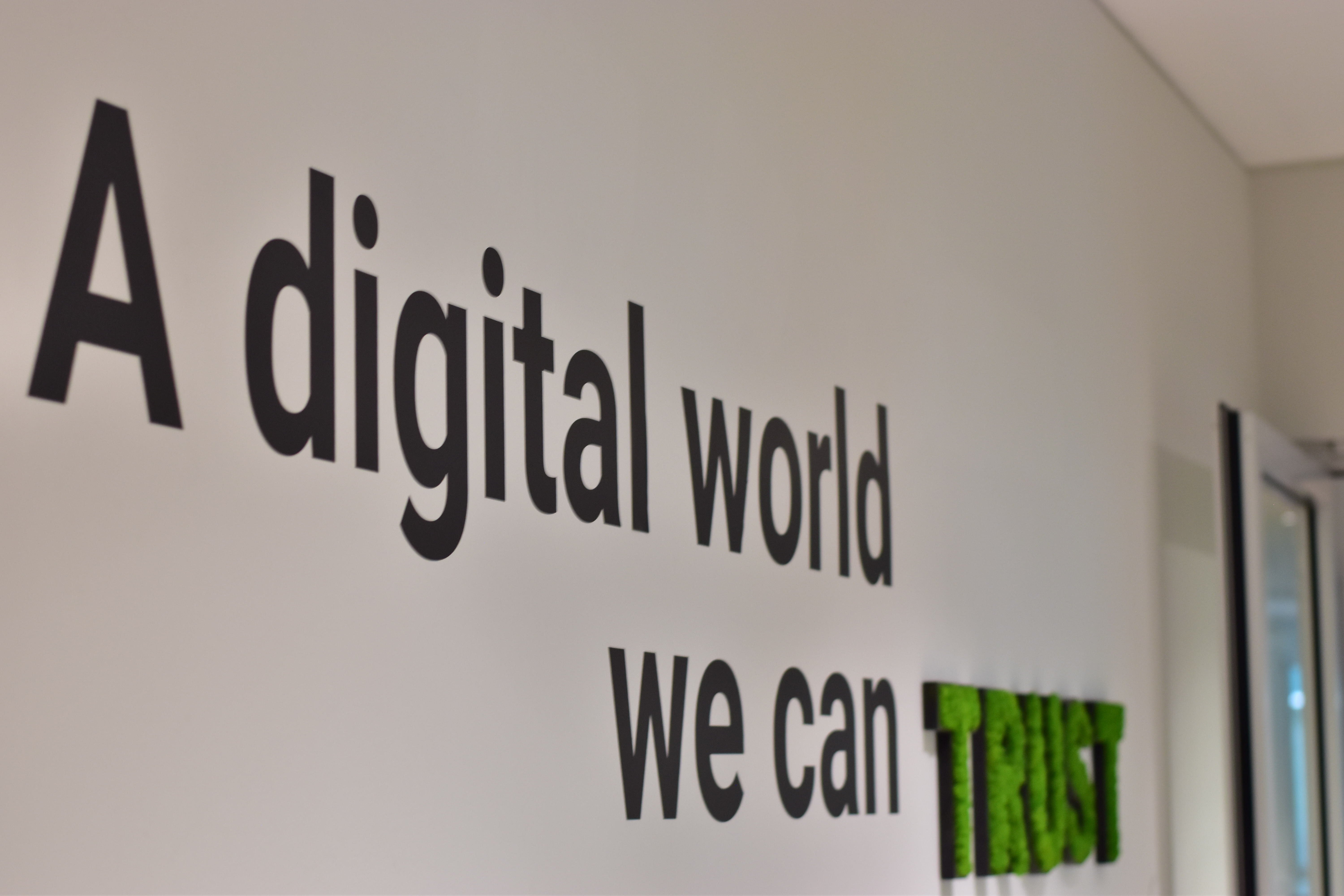 Una foto dell'ufficio di Trusted Shops con lo slogan "A digital world you can trust" (Un mondo digitale di cui ti puoi fidare) appeso alla parete.