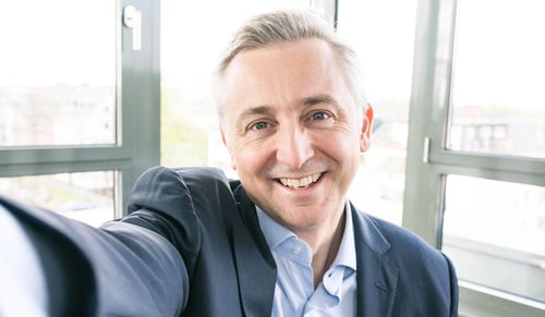 Trusted Shops CEO Jean-Marc Noel sorride alla camera mentre scatta un selfie in his office.
