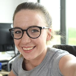 Female Trusted Shops employee smiles for a Selfie.