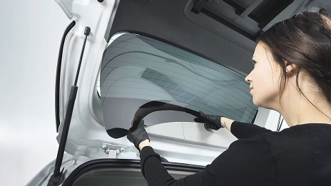 Una donna che cambia i vetri oscurati della sua auto.