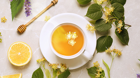 Tè con miele, limone e foglie su tavolo in stile pompadour.